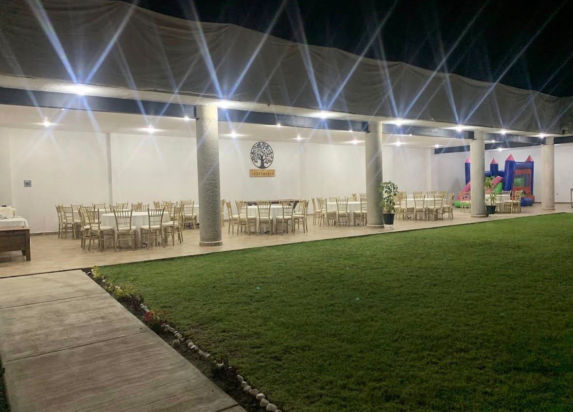 Área de banquetes iluminada de noche en Jardín Centenario